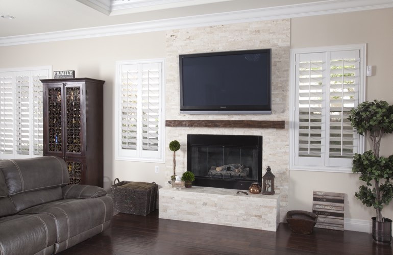 White plantation shutters in a Fort Myers living room with plank hardwood floors.